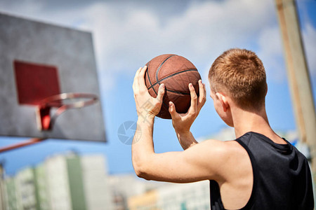 男子在户外打篮球时拿着球图片