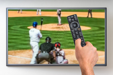 男人在电视上看棒球比赛手握着电图片
