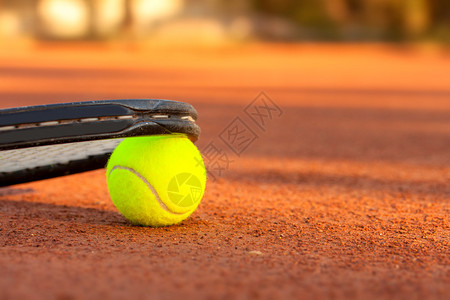 网球红土场上的网球和拍图片