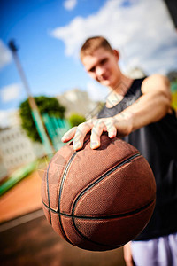 男子在户外打篮球时拿着球图片
