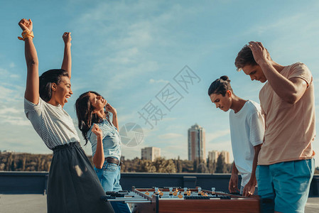 快乐的女子欢庆踢球胜利而男人填图片