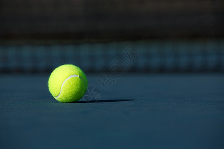 蓝色球场上的网球特写图片