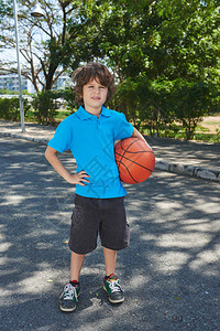 穿着蓝色马球T恤的卷毛小篮球员背景图片