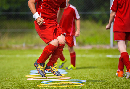 年轻的足球运动员在球场上练习足球设备动态图片