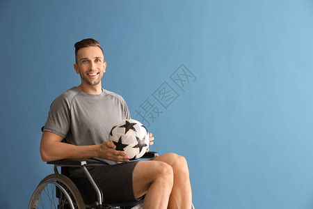 带着球的年轻人坐在轮椅上以彩图片