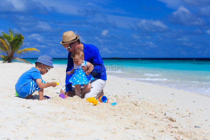 父亲和孩子在热带沙滩玩耍图片