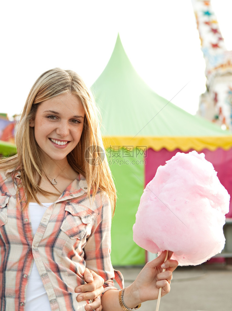 一个年轻的少女边走吃棉花糖的肖像图片