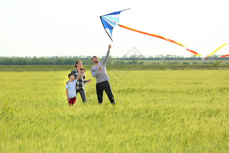 在田野放风筝的幸福家庭图片