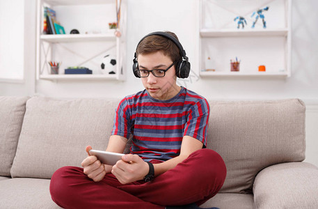 青少年在家的手机上玩网上游戏图片