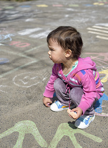 快乐的小女孩画着粉笔图片