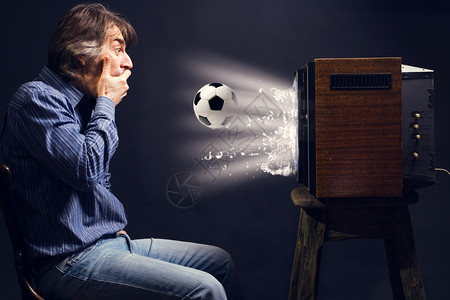 足球迷在复古电视上看橄榄球从电视上图片