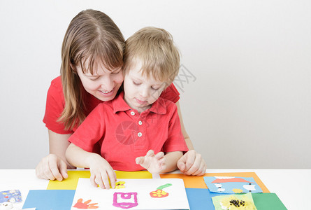 母亲和儿子玩塑料早期学习和日托图片