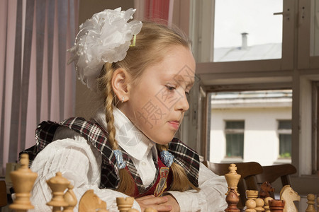 小女孩在桌边下棋图片