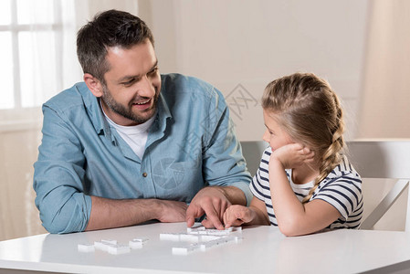 男人在家和女儿玩多米诺骨牌图片
