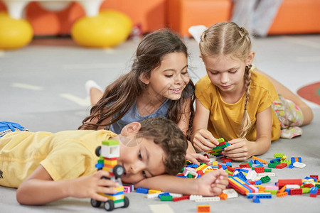 孩子们在地板上玩具快乐的孩子们在儿童中心玩积木为孩图片