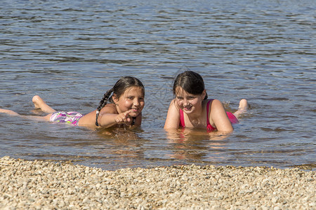 两个沙滩上玩水的女孩图片