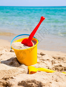 沙滩上的黄沙桶和铁锹图片