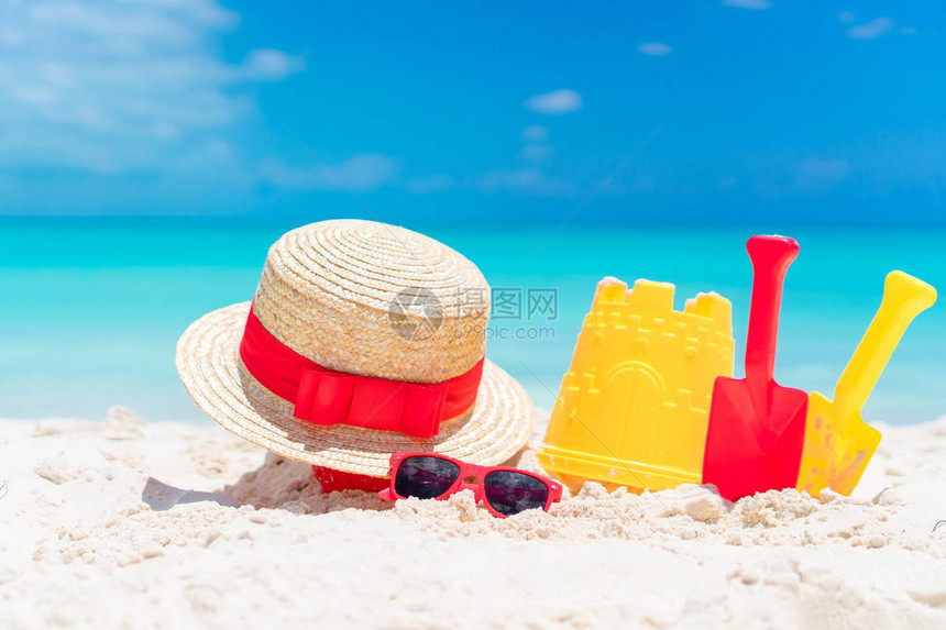 孩子们在海滩的玩具帽子和太阳镜在白沙图片