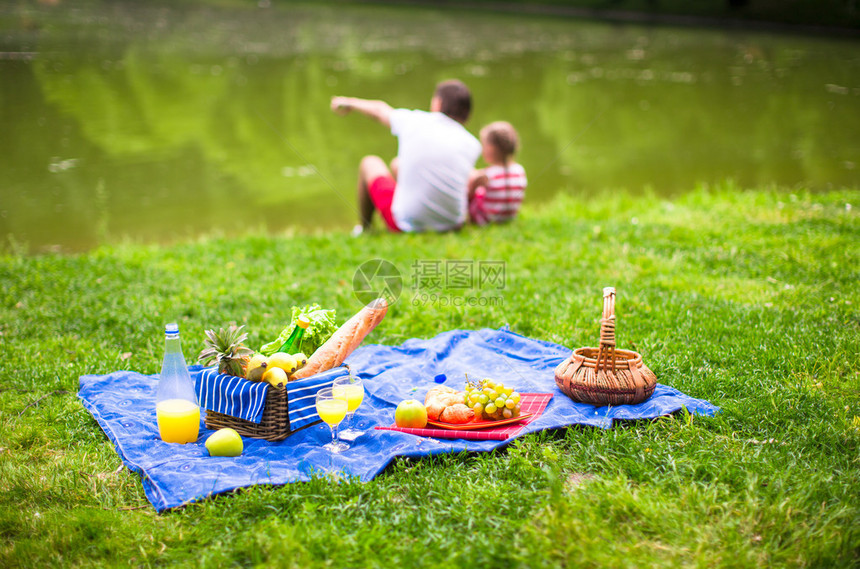 快乐可爱的一家人在公园里野餐图片