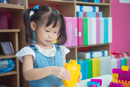 小亚洲学龄前女童在护士学校玩塑料砖游戏的年幼亚图片