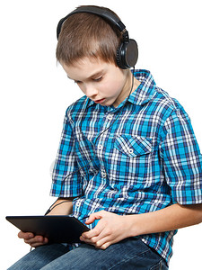 10岁男孩戴着耳机使用触摸板的肖像图片