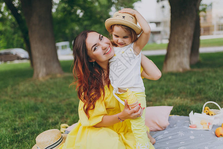 穿着黄色连衣裙的微笑女人在公园玩耍和拥抱图片