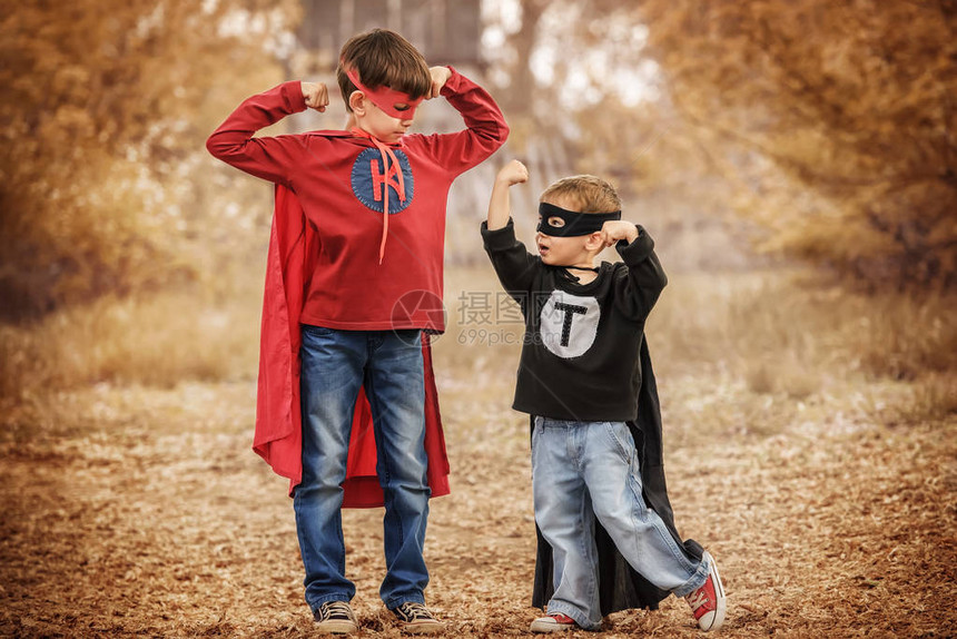 两个穿超级英雄装扮的男孩比较了他们在运动场图片