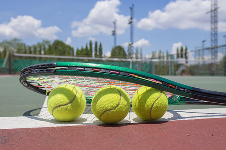 网球场上网球拍和球的近景图片