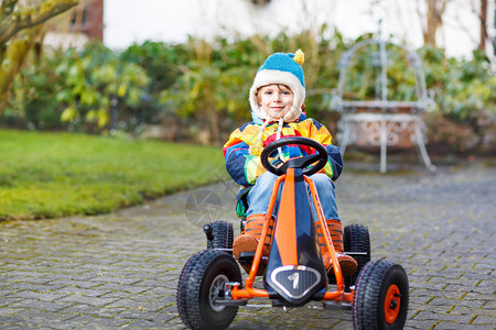 快乐活跃的小男孩在户外玩具赛车儿童驾驶汽车儿童概背景图片