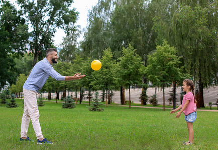 小女孩和她父亲在户外玩球图片