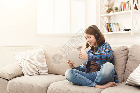 小女孩在数字平板电脑上看卡通片图片