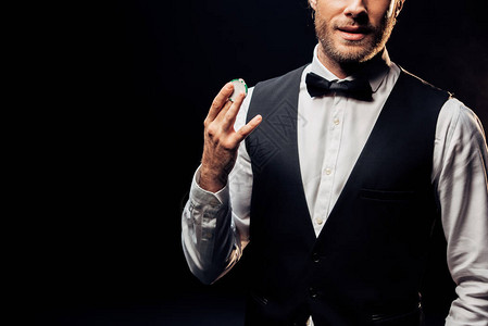 穿着正装的男人拿着被黑色隔离的扑克筹码的剪影高清图片