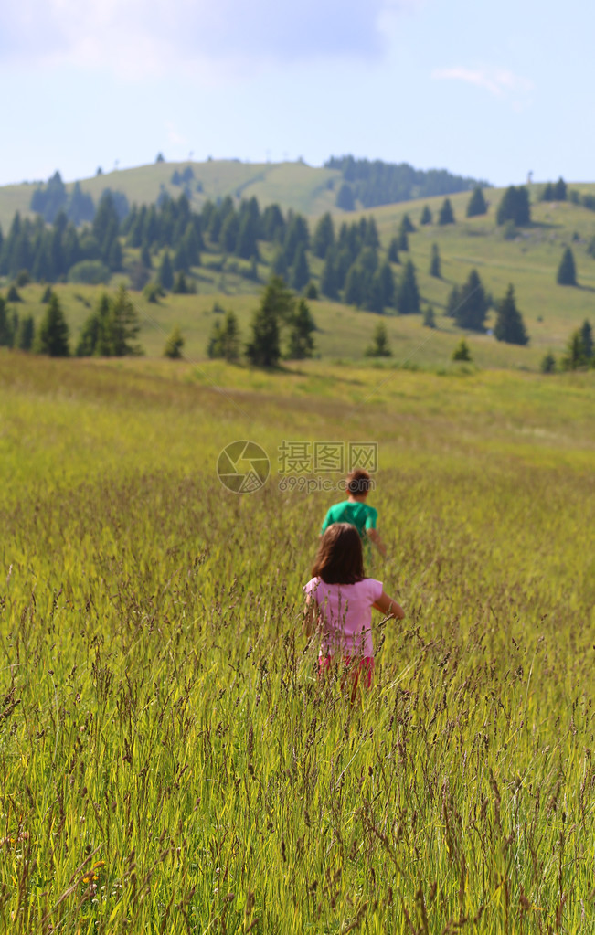 孩子们在山中草甸的高草中奔跑图片