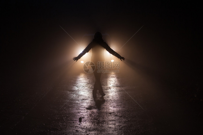 晚上在森林里一个人站在车前面的公路图片
