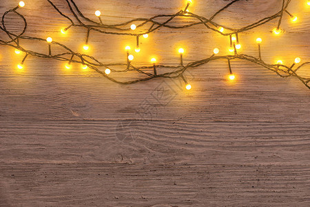 在木质背景上发光的圣诞灯背景图片