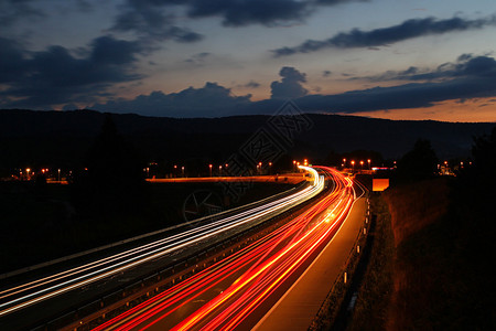 汽车交通在夜间和模糊的灯光下行驶图片
