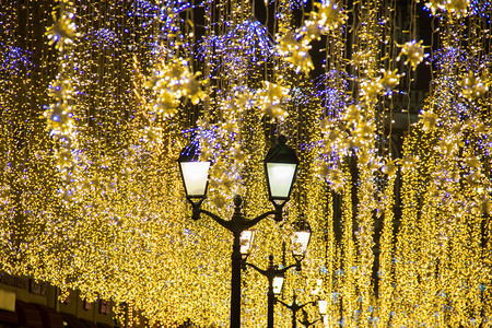 晚上在城市街道户外的圣诞和新年假期照明闪烁和挥舞着古图片
