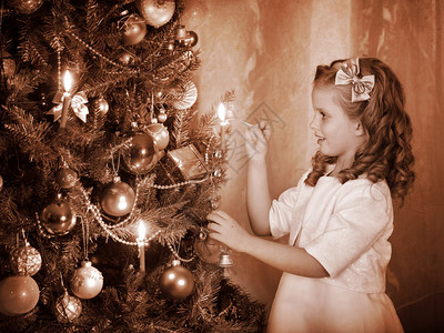 小女孩在圣诞树上点蜡烛黑白复古图片