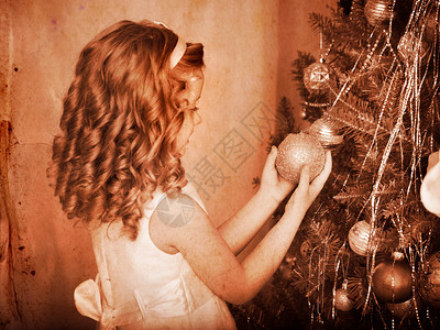 小女孩在圣诞树上装饰复古图片
