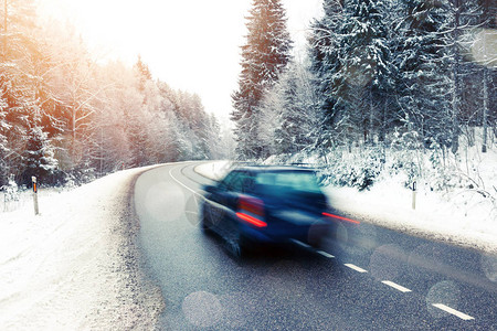 孤单的汽车在冬季风景中行驶时模糊不清图片