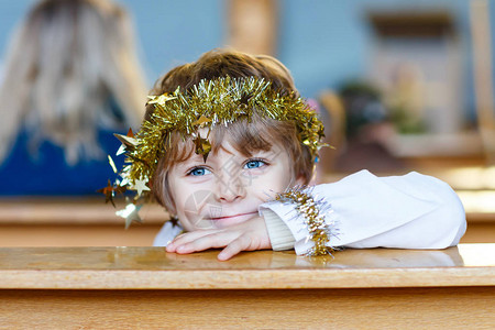 漂亮的小男孩在教堂的圣诞故事中扮演天使图片