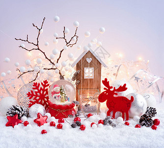 上面有圣诞装饰品和雪地上的玩具屋和圣诞灯图片