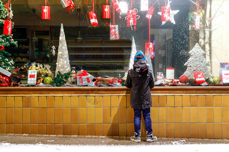 有趣的快乐孩子在时尚冬季服装制作橱窗购物装饰着礼物图片