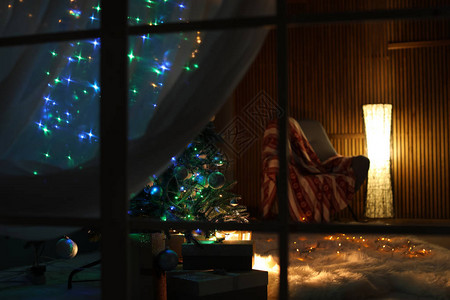 时尚的室内客厅夜间装饰圣诞树透图片