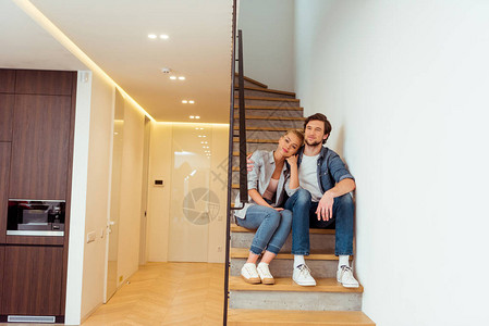 坐在家里楼梯上的恩爱夫妻背景图片