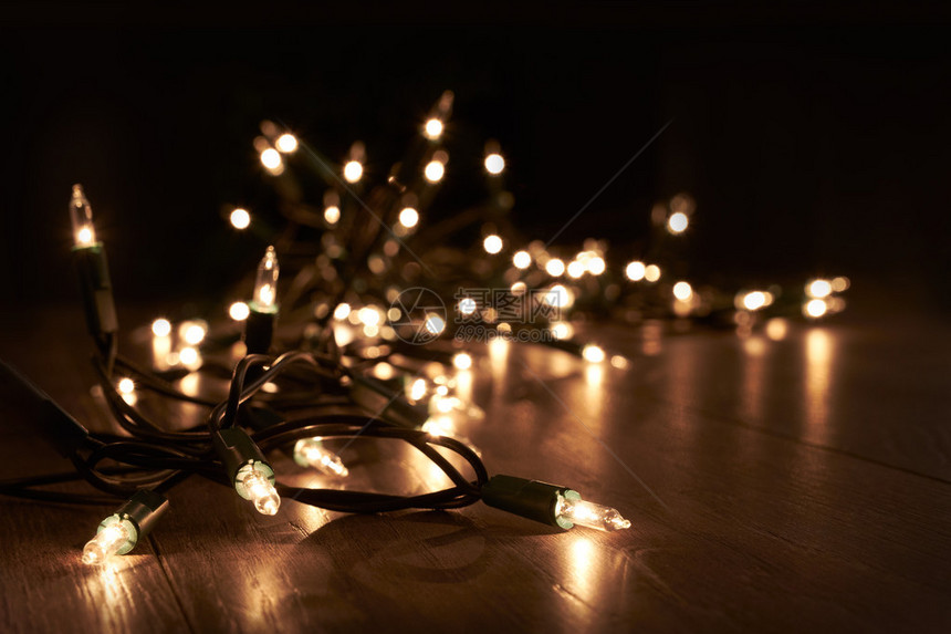 躺在木地板上的传统圣诞树灯图片