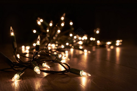 躺在木地板上的传统圣诞树灯图片
