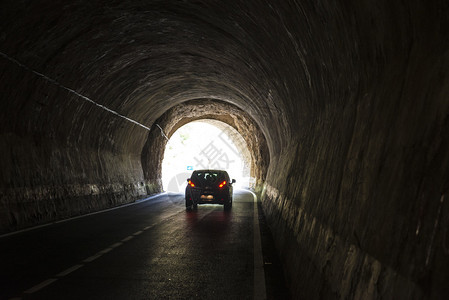 汽车在一条古老的隧道中行驶有光线进入背景图片