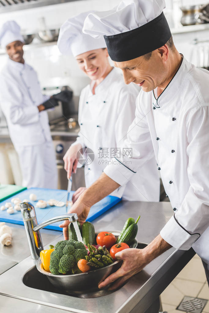 在餐厅厨房洗蔬菜的厨师图片