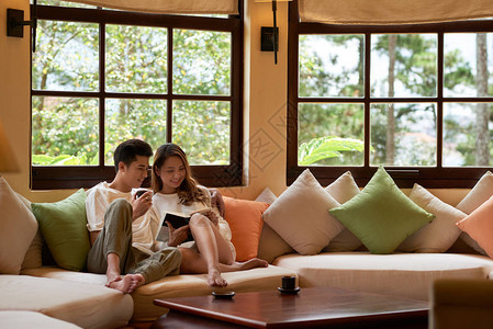 亚洲年轻夫妇在酒店享受早晨的款待图片